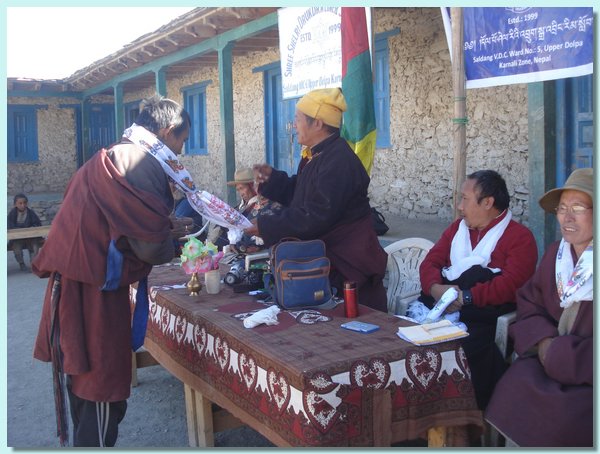 Tashi Dhondup erhaelt aus Nyima Lamas Haenden eine Khatag ueberreicht.JPG